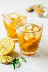 Iced tea with lemon, ginger and brown sugar in glasses. Space for text.