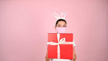 Girl holding a gift with ears in a mask
