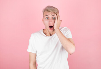 Surprised man wearing white undershirt over pink background
