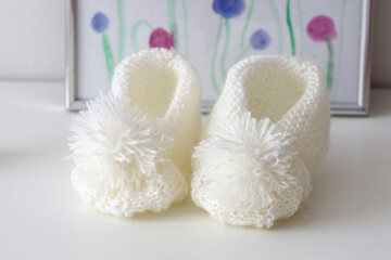 Fototapeta na wymiar hand knitted white wool baby shoes