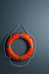 Orange lifebuoy on grey background. Rescue equipment