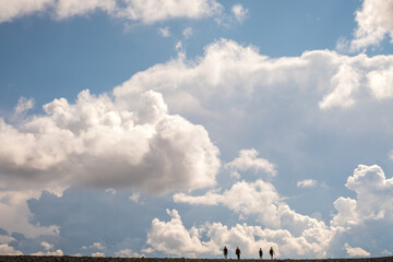 a group of people travel in the background of the sky