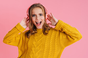 Excited beautiful blonde girl in headphones screaming at camera