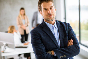 Fototapeta premium Handsome young business man standing confident in the office