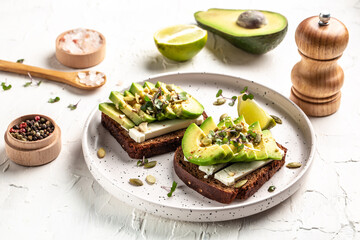 Tasty avocado sandwiches on table. The concept of eco products. Organic farm dairy products, cheeses, cereals. Vegan menu. Food recipe background. Close up