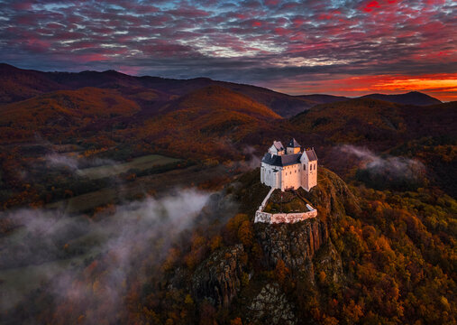 Fuzer, Hungary - Aerial view of the beautiful Castle of Fuzer with amazing colorful sunrise sky and clouds on an autumn morning. The castle has been located in the mountains of Zemplen