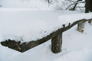 A park bench littered with fresh snow