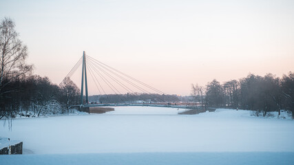 Big cable bridge over frozen and snowy water
