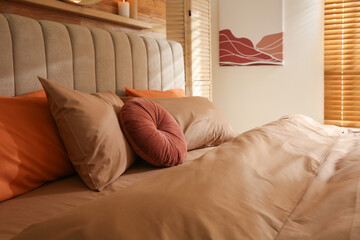 Bed with brown linens in cozy bedroom. Interior design