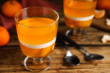Delicious tangerine jelly on wooden table, closeup