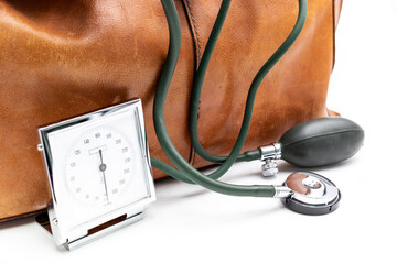 Arzttasche mit Blutdruckmessgerät, eine alte braune Ledertasche mit Griff und Metall-Verschluss.