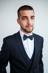 Stylish successful male businessman in a black jacket and with a bow tie