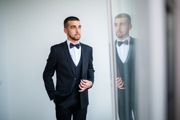 Stylish man businessman buttoning a button on a black jacket