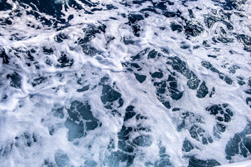 Top down aerial view of sea water surface. White foam waves texture as natural background.