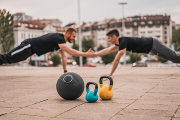 Two man doing exercises outdoors fitness athletic sports training with weights 