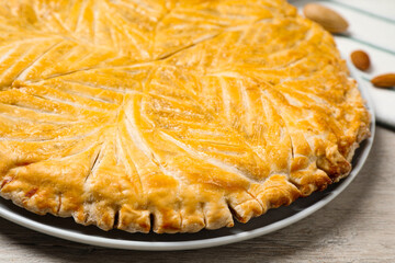 Traditional galette des rois on white wooden table, closeup