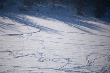 Winter sunny day in frosty forest. Blye sky, snow and sunshine. Traces on the snow