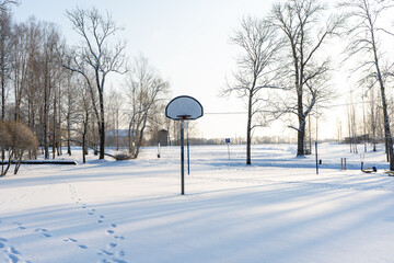 basketball court in winter is covered with white snow with a few footprints