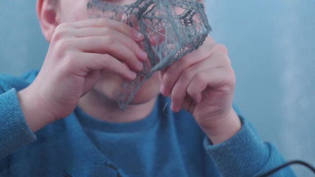 a boy makes a 3 d model with a pen. assembling the layout of the Elfin tower. young architect.