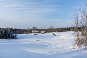 in winter a lonely old country house located in a valley surrounded by forest and has snow