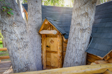 Beautiful handmade tree house door for kids in the backyard of a house
