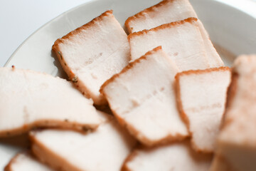 Raw chopped pork lard on a white plate, background for copy space. A large chunk of fresh fat. Ukrainian lard, traditional food.