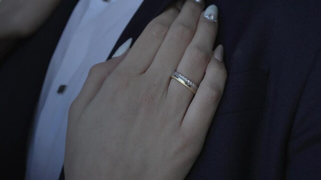Ring on the bride's hand, resting on the groom's chest