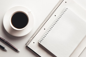 Office desk table with supplies, coffee cup and flower. Top view