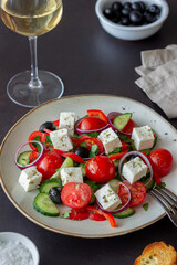 Greek salad with tomatoes, cucumbers, cheese, onions, peppers and olives. Healthy eating. Vegetarian food.