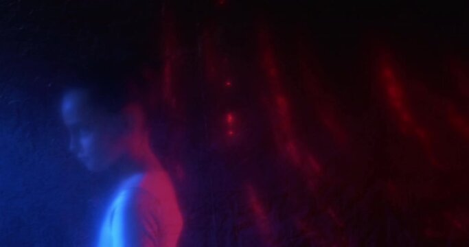 Child custody. Defocused silhouette. Social care. Kid adoption. Hopeless little orphan girl walking alone in darkness in red blue neon light behind wrinkled polyethylene film out of focus.
