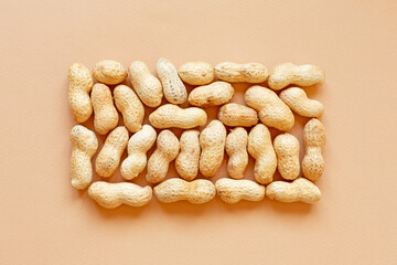 The texture with the walnuts on beige background. Peanuts in shells