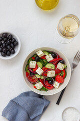 Fototapeta na wymiar Greek salad with tomatoes, cucumbers, cheese, onions, peppers and olives. Healthy eating. Vegetarian food.