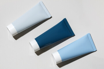 Cosmetic cream in tubes on a gray background.