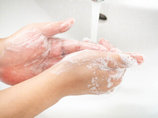 Fototapeta premium A woman cleaning hands Use hand soap until white bubbles form in the basin.