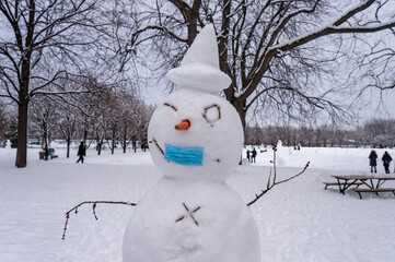 Naklejka premium Snowman wearing a protective mask during Covid-19 pandemic.