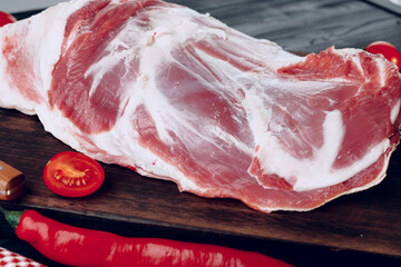 Raw lamb leg on dark wooden board