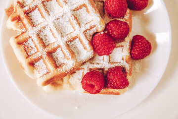 Waffle with powdered sugar and raspberries 