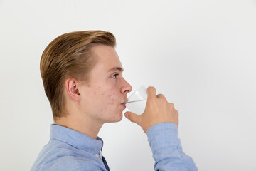 teenage boy drinking water out of a glass