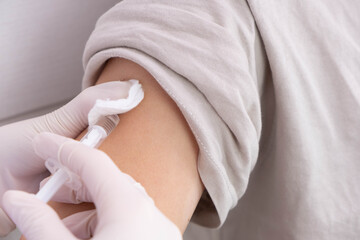 doctor in sterile gloves vaccinates the patient in the hand