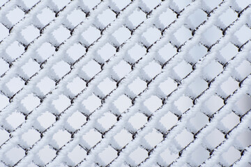 Frost-covered metal mesh. Winter background.
