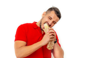 Young adult man with beard eating delicious fresh crunchy Shawarma on white background