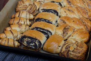 Rich pastries. The buns are on a baking sheet. Filling with poppy seeds, walnuts. Close-up shot.