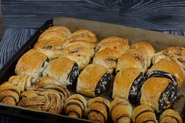 Rich pastries. The buns are on a baking sheet. Filling with poppy seeds, walnuts. Close-up shot.
