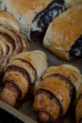 Rich pastries. The buns are on a baking sheet. Filling with poppy seeds, walnuts. Close-up shot.