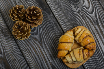 Cinnamon croissants. Rich pastries. Nearby pine cones. Close-up shot.