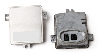 Fototapeta na wymiar Spare part plastic car engine control unit with metal elements on a white isolated background is the connecting center subsystems, units and assemblies. Rear view of the electronic xenon ignition unit