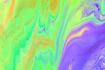 Blue-yellow-green abstract marble background. The acrylic paint mixes freely and creates an...