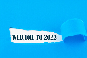 WELCOME TO 2022 words written under ripped and torn paper.