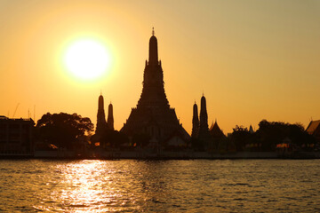 Fototapeta premium Bright Sun Shining over the Silhouette of Wat Arun or the Temple of Dawn, the Best Known Landmark of Thailand