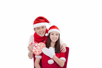 Portrait of young couple wearing Santa hats,holding gift